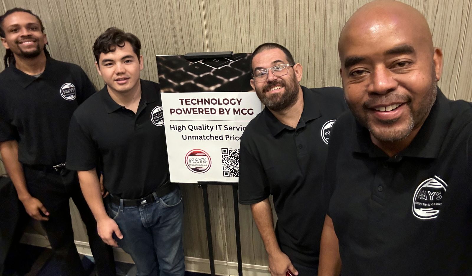 The MCG team in matching black polos at a conference